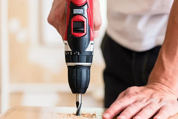 Person bohrt mit Akkuschrauber in Holz